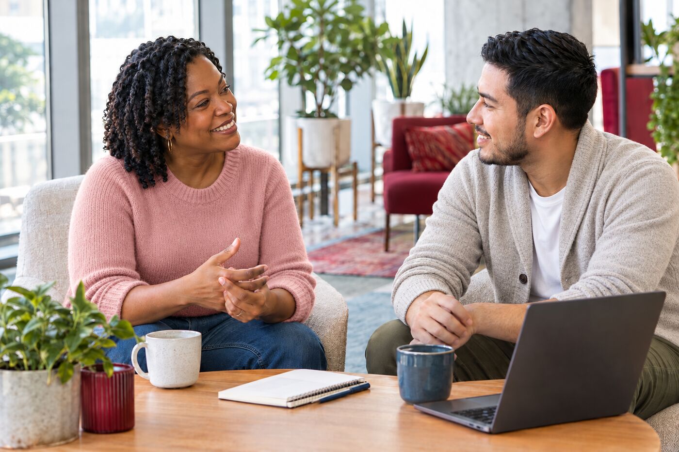 A Black woman HR consultant and a Latino colleague having a relaxed conversation over coffee